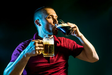 man enjoys drinking and enjoying light and dark beer on a dark background