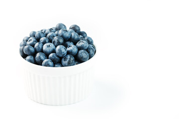 Blueberries in a white Cup on a white background. Isolate, free space