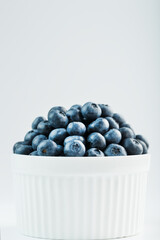 Juicy Blueberries in a white Cup on a white background.