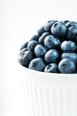 Juicy Blueberries in a white Cup on a white background.
