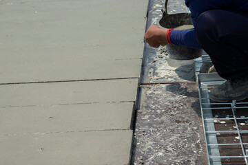 cement surface adjusting with hand of worker and waiting for cure by sunligth in out door in hands hold spong