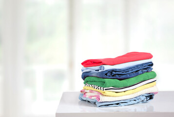 Stack of colorful clothes on table empty copy space,cotton clothing pile.