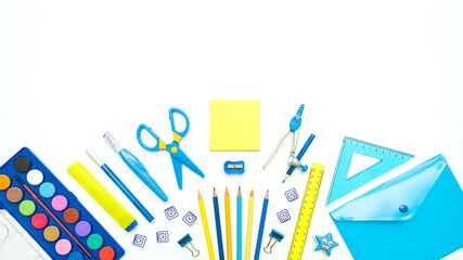 Stationary supplies in yellow and blue colors for school, university, office on white background. Empty space. Flat lay, banner.