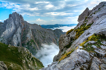 Fototapeta na wymiar Mar de nubes entre las montañas de los Picos de Europa, con la Torre de El Friero a la izquierda y el Valle de Valdeón cubierto con nubes con un cielo azul nublado