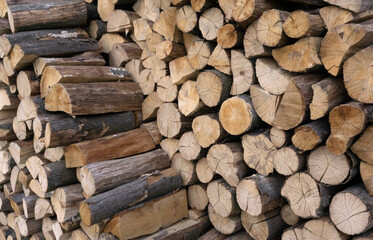 Stack of old firewood texture background. Firewood for the winter, stacks of firewood, pile of firewood. Fireplace wood, cordwood, splitwood.stored logs, wood and lumber.