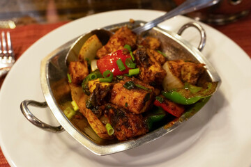 Chili paneer close up shot at the traditional Indian restaurant. Portrait of Indian vegetables jalfrezy with seasoning. Paneer Indian vegetarian masala gravy asian meal with vegetables. 