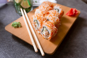 Traditional asian food sushi on the wooden plate with wasabi and ginger. Traditional cuisine. Sushi with chopsticks. 