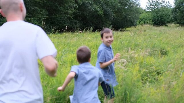 family, man and children walk among meadows and forests in summer, the concept of family summer vacations, picnics, vacations, camping, activity in the park