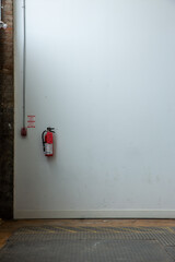 empty wall with single fire extinguisher 