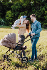 Fototapeta premium Happy mom holds the baby in her arms and kisses him