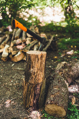 Axe for cutting wood. Close-up of an axe cutting a log, while other logs lie in the background.
