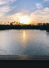 Sunset on the horizon observed on a bridge over a lake 