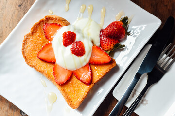Toast with Yogurt , strawberry and  honey  in  white plate on  wooden table, Breakfast baked