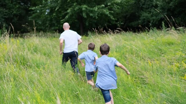 family, man and children walk among meadows and forests in summer, the concept of family summer vacations, picnics, vacations, camping, activity in the park