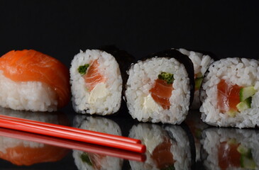 Salmon rolls or Maki-zushi. on black background with reflection