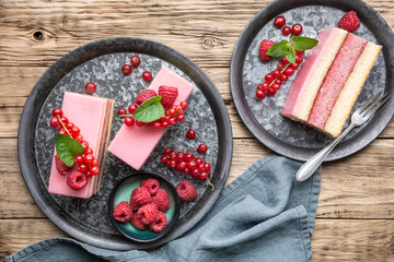 Delicious and refreshing juicy dessert, punch cake topped with sugar icing and fresh raspberries and red currants