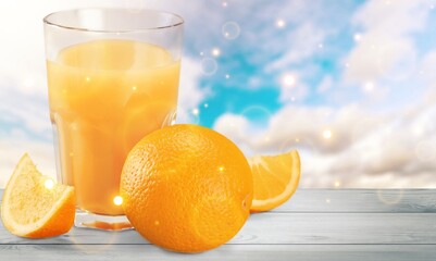 Orange juice and slices of orange on wooden desk