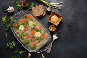 Fototapeta na wymiar Home made aspic, jellied chicken meat with herbs and carrots. Traditional Russian dish holodets. Served with bread and mustard or/and horseradish
