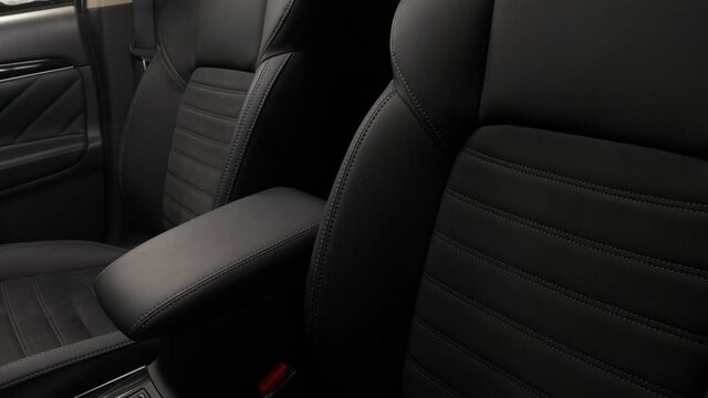 Panning from down to up of the interior of a luxury car with leather upholstery seats and door.