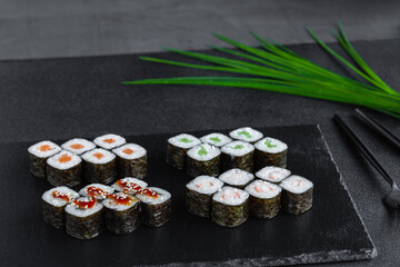 Portion of classic fresh sushi rolls with nori, salmon, cucumber, smoked eel