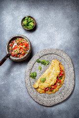 Big potato pancake with tomato sauce salsa on gray plate, gray background, top view