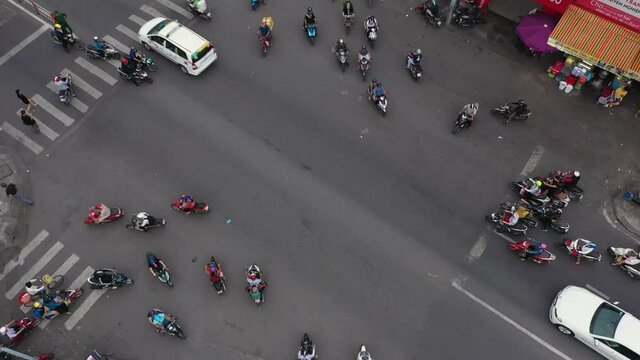 Top down drone shot of a busy intersection watching the organized chaos of the of the Saigon motor cycle traffic