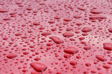 Rain drops on a red glossy surface