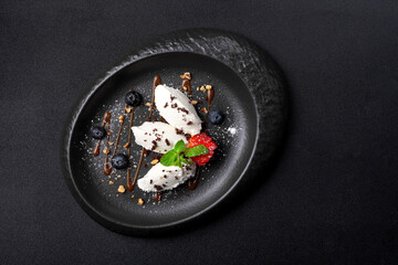 Dessert in oval plate, vanilla ice cream, blueberry, strawberry, caramel sauce