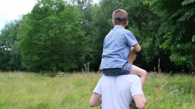 kid, boy sitting on the neck man, father, concept of family summer vacation, outdoor games, family summer vacation, vacation, camping, forest