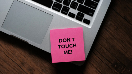 Don't Touch ME! message concept written post it on laptop keyboard.
