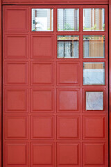 Red closed wood door with glass window