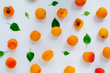 Apricots and green leaves on a white background