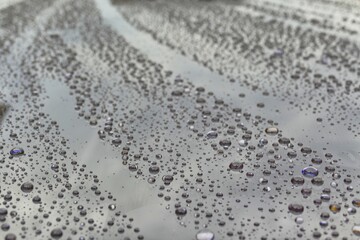 Rain drops on a gray glossy surface