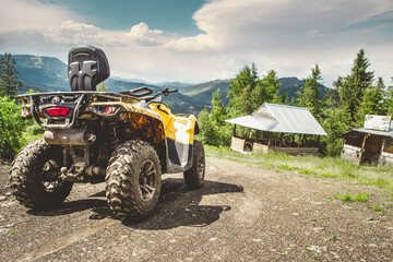 Yellow quadbike in the mountainian road woth some beautiful mountains behind. 