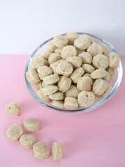 Pressed oat bran in a glass bowl on a pink background