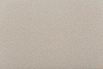 Textile surface of beige color with lines embossed. Background design.