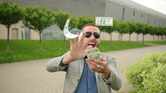 Posh rich man throws money away. Office manager outside fling one hundred dollar bills. Businessman's hand throwing made of US Dollars. Letting go the material objects that control me.