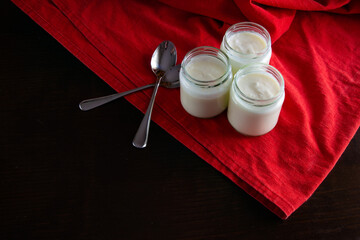 Three glasses of yogurt on a wooden table