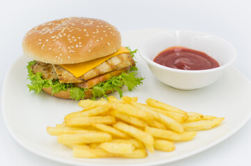 Grilled chicken burger with ketchup and fries on the side. 