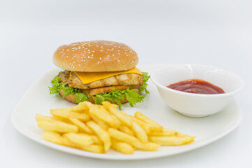 Grilled chicken burger with ketchup and fries on the side. 