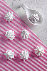 White meringues on pink and white background