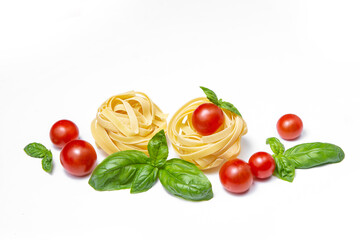 Cherry tomatoes, pasta and basil leaves on a white isolated background. Copy space. Gamedients for dinner.