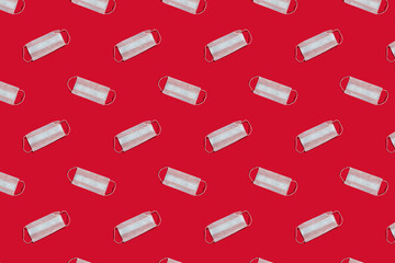 Pattern and medical reusable masks on a red background. Concept of pandemic, epidemic, virus, quarantine.