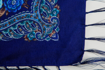 top view part of bright paisley floral pattern on dark blue cotton female shawl