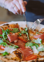 woman cutting pizza close up