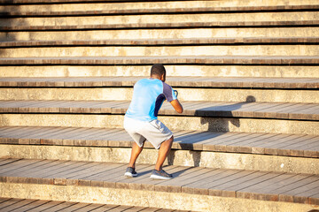 Deportista negro haciendo saltos en las escaleras del Parque de Cabecera de Valencia