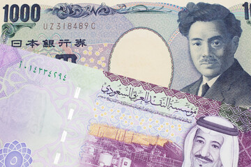A one thousand Japanese yen bank note, close up in macro with a five riyal bank note from Saudi Arabia