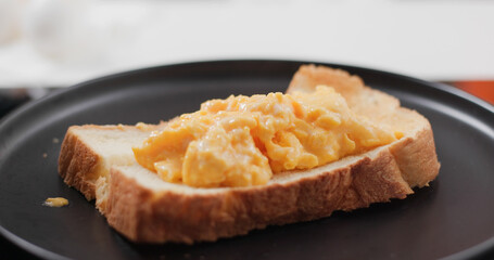Seasoning scrambled eggs on toast