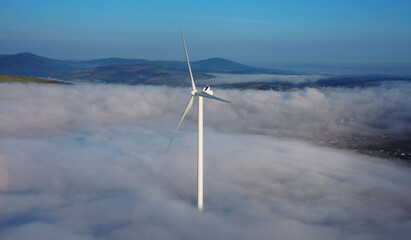 Wind turbine over morning fog