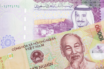 A colorful ten thousand dong note from Vietnam close up in macro with A colorful, five Saudi riyal bank note